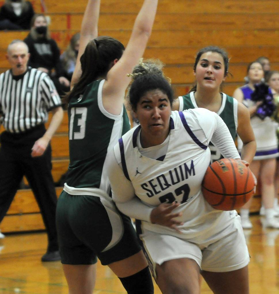Sequims Jelissa Julmist, right, drives past Port Angeles Bailee Larson in the second half of Sequims 60-55 win over the Roughriders on Jan. 11. Sequim Gazette photo by Michael Dashiell