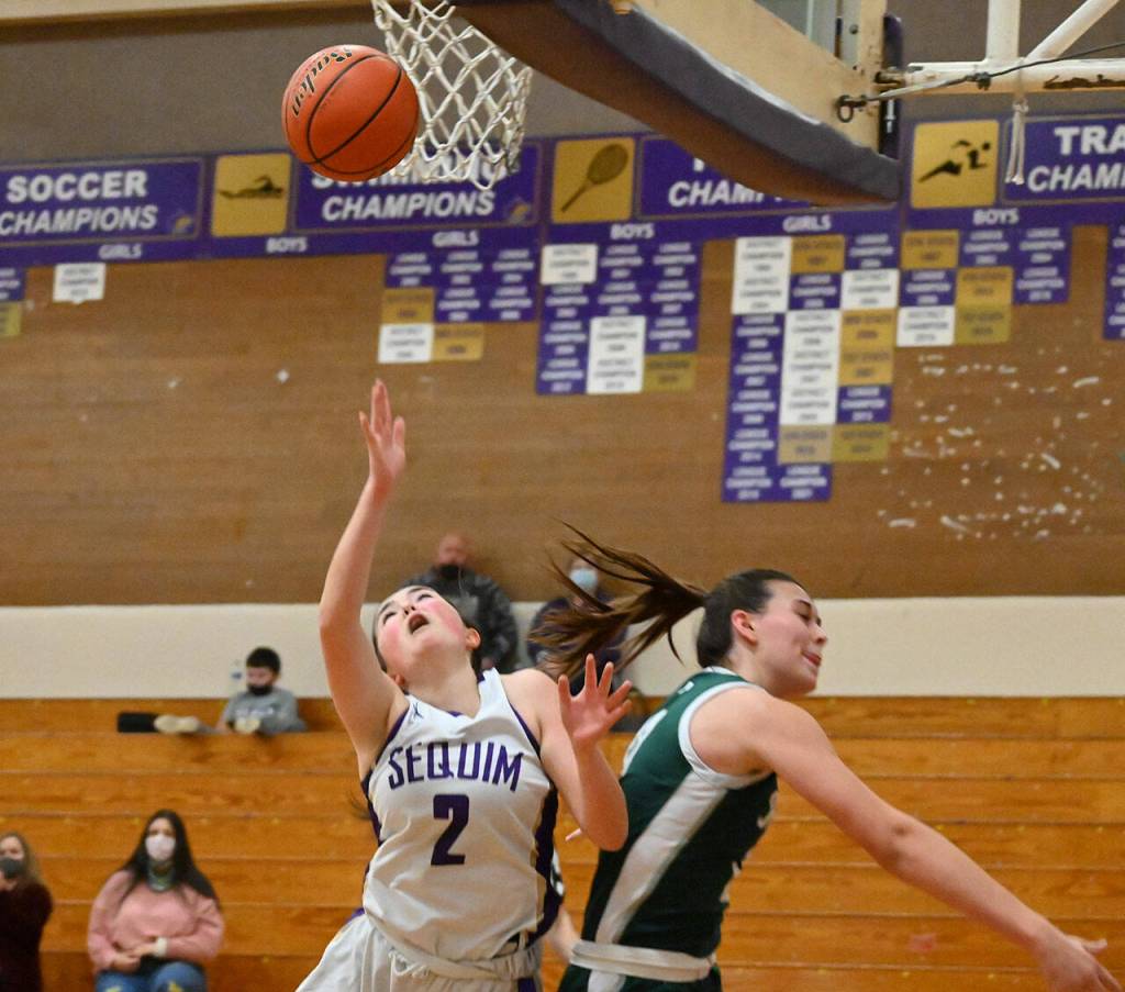 Sequim guard Hannah Bates, left, gets fouled on the way to the basket by Bailee Larson in the Wolves 60-55 win over Port Angeles on Jan. 11. Sequim Gazette photo by Michael Dashiell