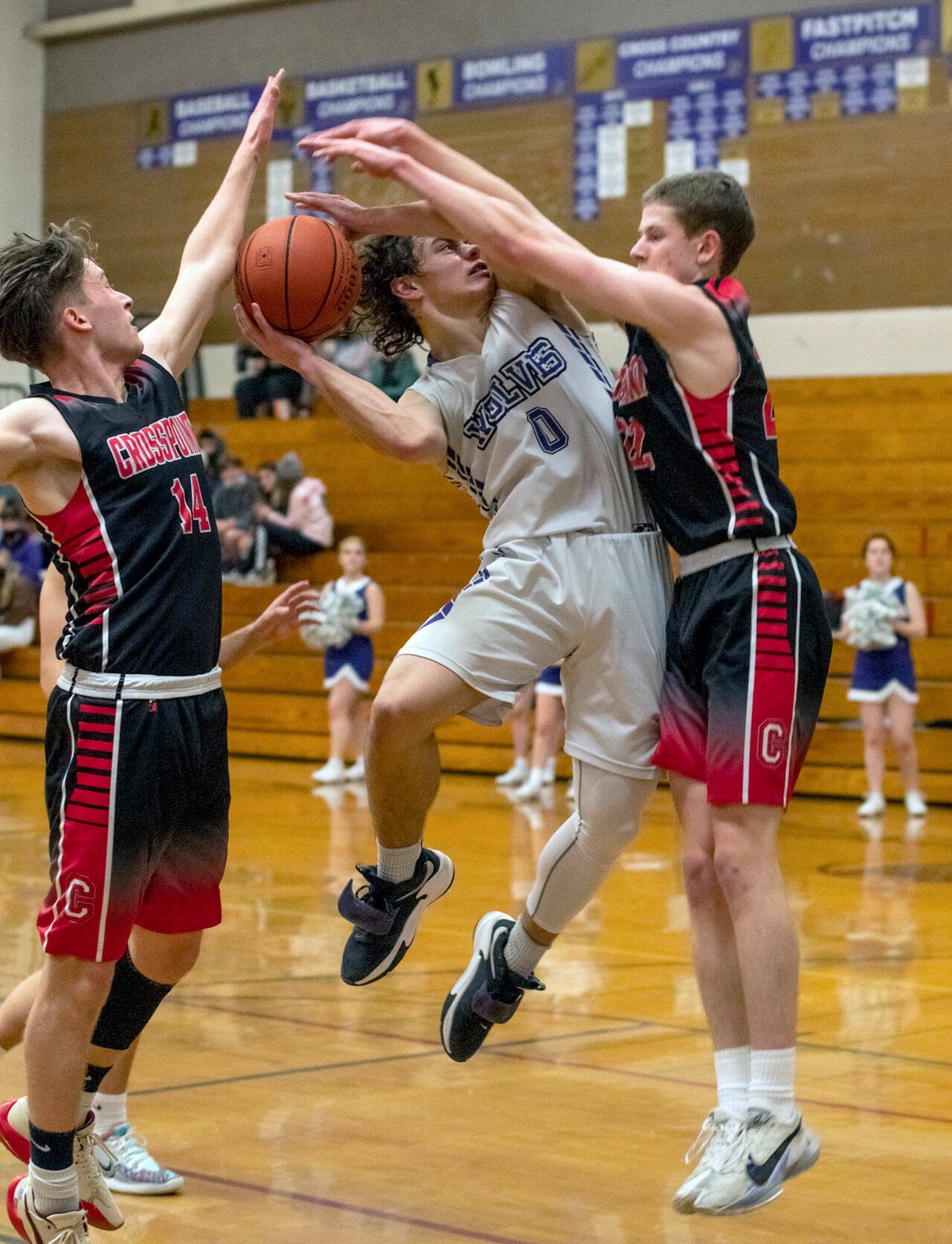 Sequim Gazette photo by Emily Matthiessen
Sequims Tyler Mooney, center, looks for a basket in the midst of Crosspoint defenders in the Wolves 63-62 non-league home loss on Jan. 14.