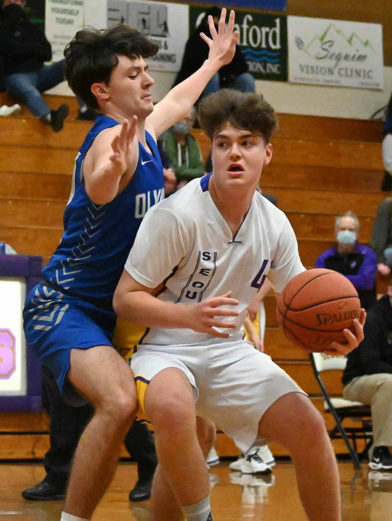 Sequims Keenan Green, right, drives past Olympics Dylan Boschee-Perry in search of a basket in the Wolves 53-39 win on Jan. 17.
