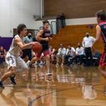 As Sequim guard Tyler Mooney, left, brings the ball upcourt, Crosspoint Academy coach Darren Doty (background, standing) looks on. Doty played for the Wolves, helping lead Sequim to its lone state championship game appearance against Rainier Beach in 1988. Sequim Gazette photo by Emily Matthiessen