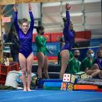 As teammates look on, Sequims Alex Schmadeke competes in the floor exercise in a league meet on Jan. 19 in Port Angeles.