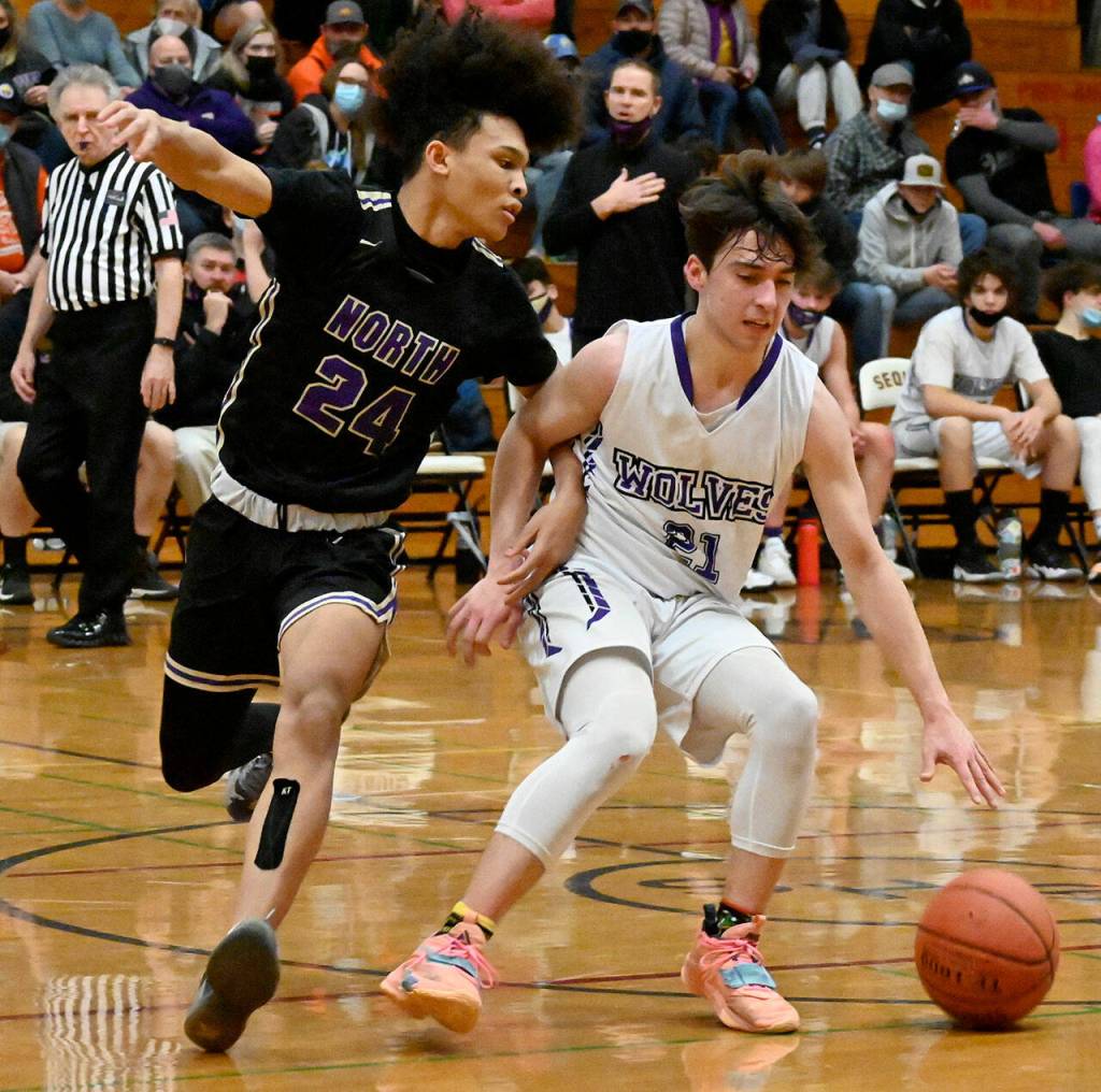 Sequim guard Jayden Possin, right, keeps the ball away from North Kitsap guard Jalen East in the Wolves 78-40 loss to the top-ranked Vikings on Jan. 20. Sequim Gazette photo by Michael Dashiell
