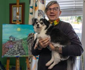 Sequim Gazette photo by Emily Matthiessen
Artist Craig Robinson and his dog, Flareon, share the painting he will contribute to Sequims City Arts Advisory Commissions outdoor recycled and reused art show Art All Over, The Art Show Without Walls. Robinsons painting, Octopus Man depicts a building on Cline Spit, built in the 1940s. He was told that the original owner was an octopus hunter. The painting was made on recycled wood with a coat of Helmsman varnish to protect it in the outside weather. The commission is hoping for many more submissions and has extended the deadline.