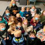 Submitted photo
At right, students in Stephanie Nashs kindergarten class at Helen Haller Elementary visit with fifth-grader Kendall Adolphe and her chickens, Cop and Rose.