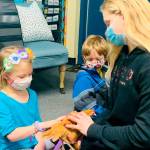 Kindergartners Malta Bushy, left, and Andrew Van de Weghe visit with fifth-grader Kendall Adolphe and her chicken. Submitted photo