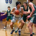 Sequims Isaac Moore, center, looks for room to put up a shot in the Wolves 62-49 loss on Feb. 3. Sequim Gazette photo by Emily Matthiessen