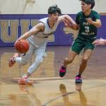 Sequim guard Jayden Possin, left, drives past Port Angeles Quanah Wheeler in a Feb. 3 Olympic League match-up. Sequim Gazette photo by Emily Matthiessen