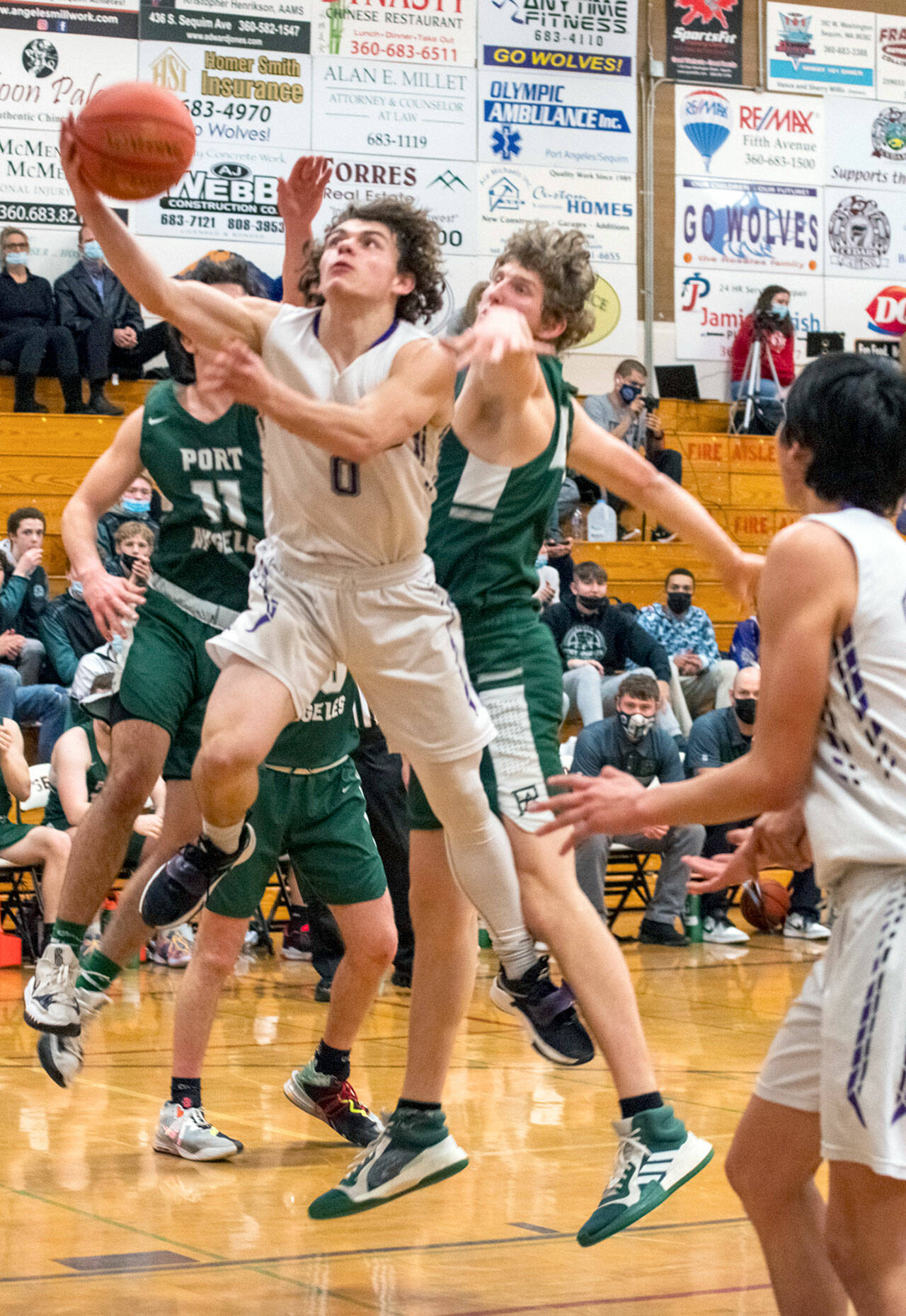 Sequim Gazette photo by Emily Matthiessen
Sequims Tyler Mooney puts up a layup while defended by Port Angeles Xander Maestas, at left, and John Vaara during the Wolves 62-49 loss on Feb. 3.