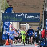 Sequim Gazette photos by Michael Dashiell
Above: Participants break from the starting line at the Elwha Bridge 5k/10k on Feb. 5. Below: Elwha Bridge 5k champ Leia Larson, 13, of Port Angeles, gets congratulated at the finish line as she talks with runner-up Shannon Newman of Maple Valley.