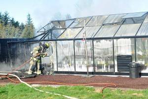Clallam County Fire District 3 firefighters contain hot spots in a greenhouse fire on Wednesday, Feb. 16 near Heath Road. Sequim Gazette photo by Matthew Nash