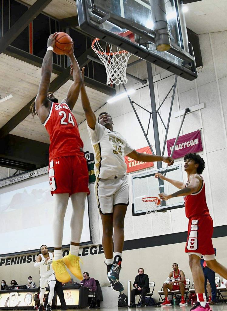Peninsula's Isaiah Sampson, center, battles with Skagit Valley's Etan Collins for a rebound in the Pirates' 83-69 home win over Skagit on Feb. 17. Sampson led PC with 16 points. Photo by Jay Cline/Peninsula College