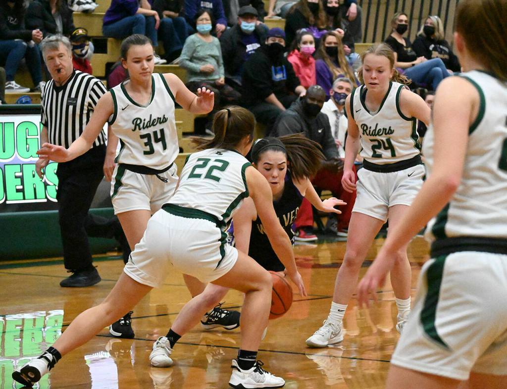 Port Angeles Lexie Smith (34), Eve Burke (22) and Anna Petty (24) surround Sequim guard Hanna Bates in the first half of a district tourney payoff game in Port Angeles on Feb. 17. Sequim Gazette photo by Michael Dashiell