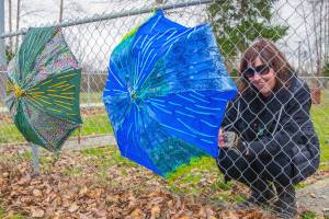 Sequim Gazette photo by Emily Matthiessen
Brigitte Schlemmer of Sequim hangs a Flumbro: an umbrella repurposed with materials like yarn and buttons in Carrie Blake Community Park. Schlemmer encourages other people to submit their imperfect art to Sequim Citys Art Commissions Art All Over - The Art Show Without Walls via a link: sequimwa.gov/1008/Art-All-Over-The-Art-Show-Without-Wall. Submissions will be accepted for months in the hope that more people will submit their art for hanging in Sequim city parks. See story, B-1.