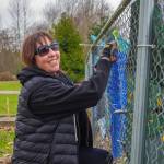Brigitte Schlemmer of Sequim hangs a Flumbro: an umbrella repurposed with materials like yarn and buttons in Carrie Blake City Park. Schlemmer encourages other people to submit their imperfect art to Sequim Citys Art Commissions Art All Over - The Art Show Without Walls via a link at sequimwa.gov/1008/Art-All-Over-The-Art-Show-Without-Wall. Submissions will be accepted for months in the hope that more people will submit their art for hanging in Sequim city parks. Sequim Gazette photo by Emily Matthiessen