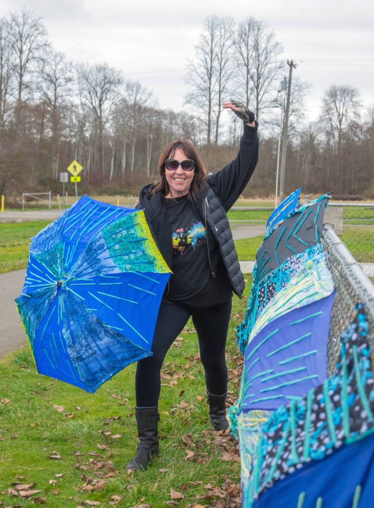 Brigitte Schlemmer of Sequim plays with one of her Flumbros  umbrellas repurposed with materials like yarn and buttons, in Carrie Blake Community Park. Schlemmer encourages other people to submit their imperfect art to Sequim Citys Art Commissions Art All Over ­ The Art Show Without Walls via a link: sequimwa.gov/1008/Art-All-Over-The-Art-Show-Without-Wall. Submissions will be accepted for months in the hope that more people will submit their art for hanging in Sequim city parks.
