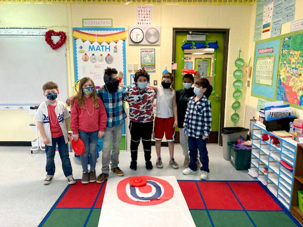 Submitted photo
Helen Haller Elementary students (from left) Aiden Fazio, Bristol Bury, Jalen Williams, Manuel Yanez, Walter Thomas, Kyrie Marchbanks and Isaac Malkasian wait to try their hand at curling. Their class recently learned about the Winter Olympics.