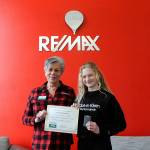Sequim Gazette photo by Matthew Nash 
Liz Parks, president of RE/MAX Prime, presents fifth grader Kendall Adolphe with a certificate and gift card for winning the Sequim Irrigation Festivals button design contest.