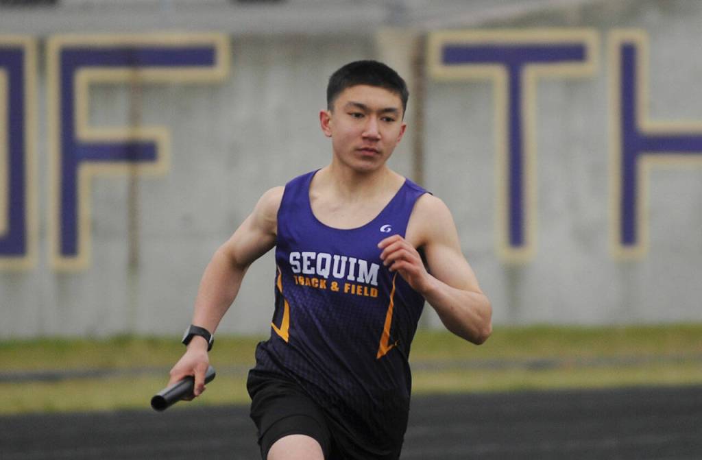 Sequims Koda Robinson competes in the 4x400 relay in the Wolves season-opening meet against Olympic in March 2021. Sequim Gazette file photo by Michael Dashiell