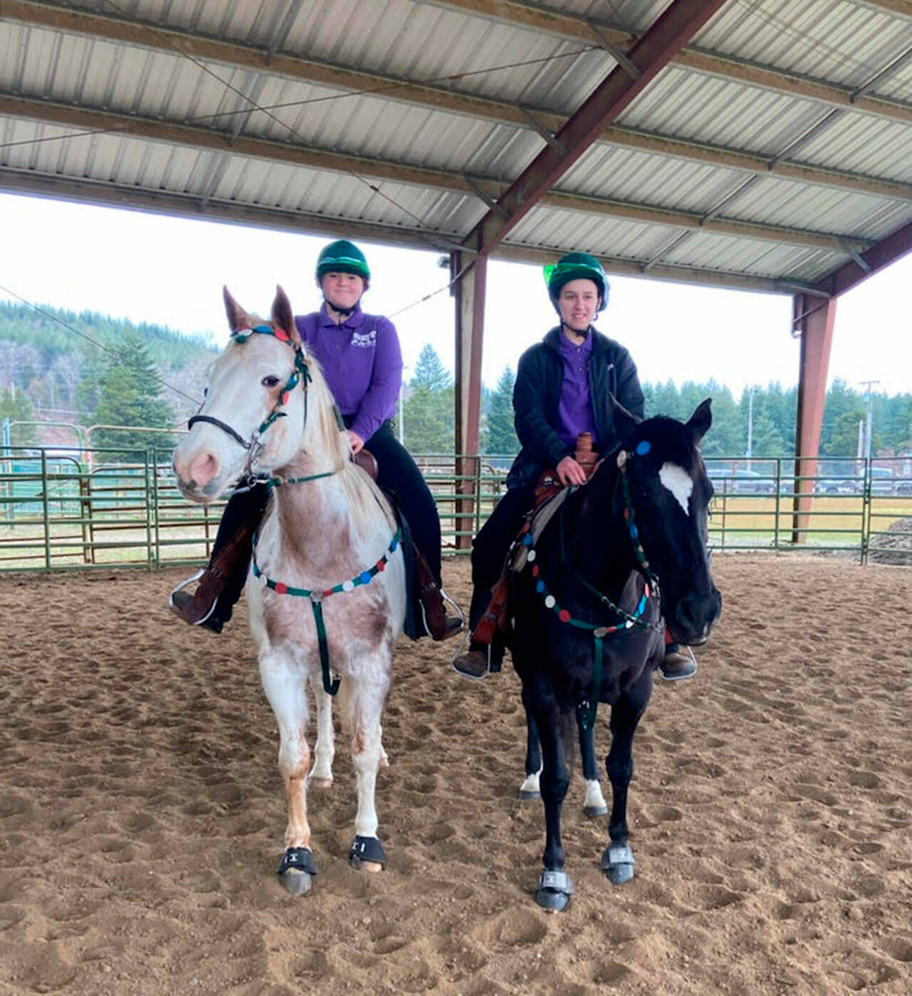 Sequim equestrians Joanna Seelye, left and Mia Kirner getting ready to compete in the Working Pairs event at their teams second meet of the season, held Feb. 24-27 in Elma. The duo placed third. Submitted photo