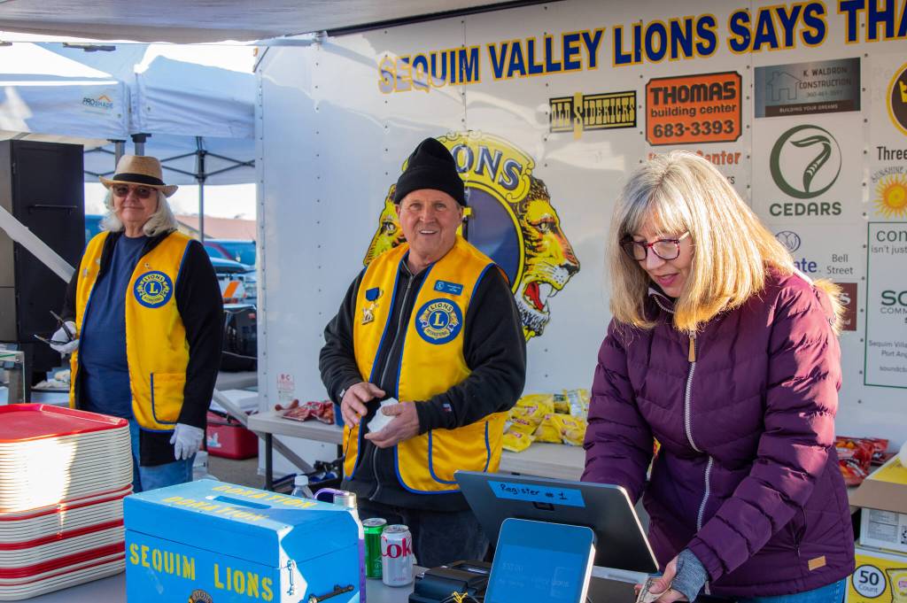Louanne Linder, John Riley and Linda Alders, volunteers at the Sequim Valley Lions' food stand, raise money for the club's general fund  at the Sequim Sunshine Festival Market on March 5. Sequim Gazette photo by Emily Matthiessen