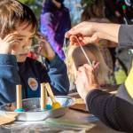 Five-year-old Jordan Dix watches intently as a volunteer demonstrates how to put together a sun luminary at the Let Your Little Light Shine Luminary Workshop during Sequims third annual Sunshine Festival. Sequim Gazette photo by Emily Matthiessen