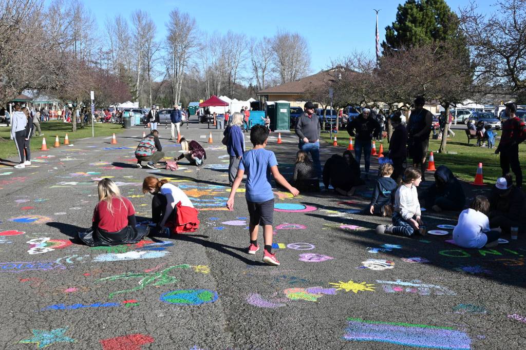 Youngsters and adults alike enjoy the Community Street Mural Art Project at Carrie Blake Park on March 5, part of the 2022 Sequim Sunshine Festival. Sequim Gazette photo by Michael Dashiell