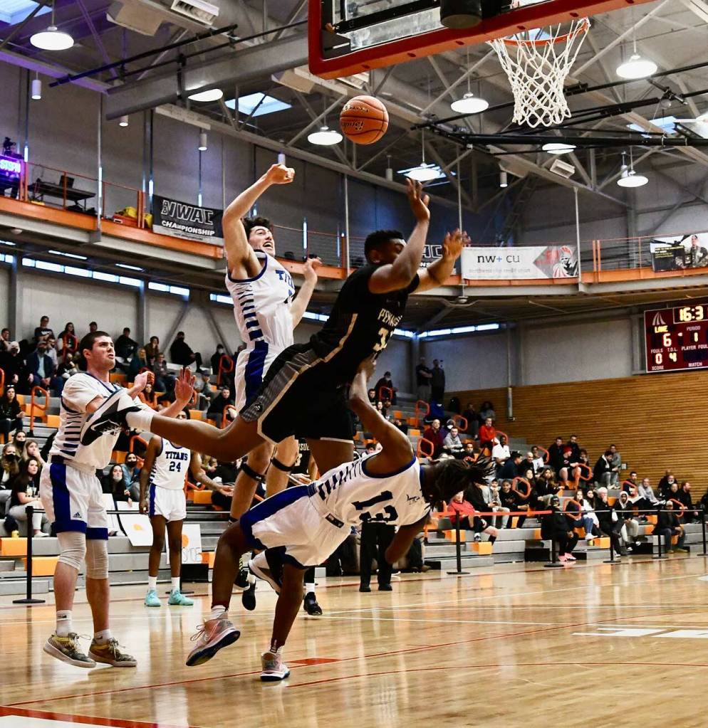 Peninsula College Photos by Jay Cline
Peninsulas Isaiah Sampson, center, bowls over Lanes Tyshawn Ford on his way to the basket in an NWAC tournament first round game in Everett on March 17. Sampson had nine points and eight rebounds but the top-seeded Lane ended PCs season with an 82-68 victory.