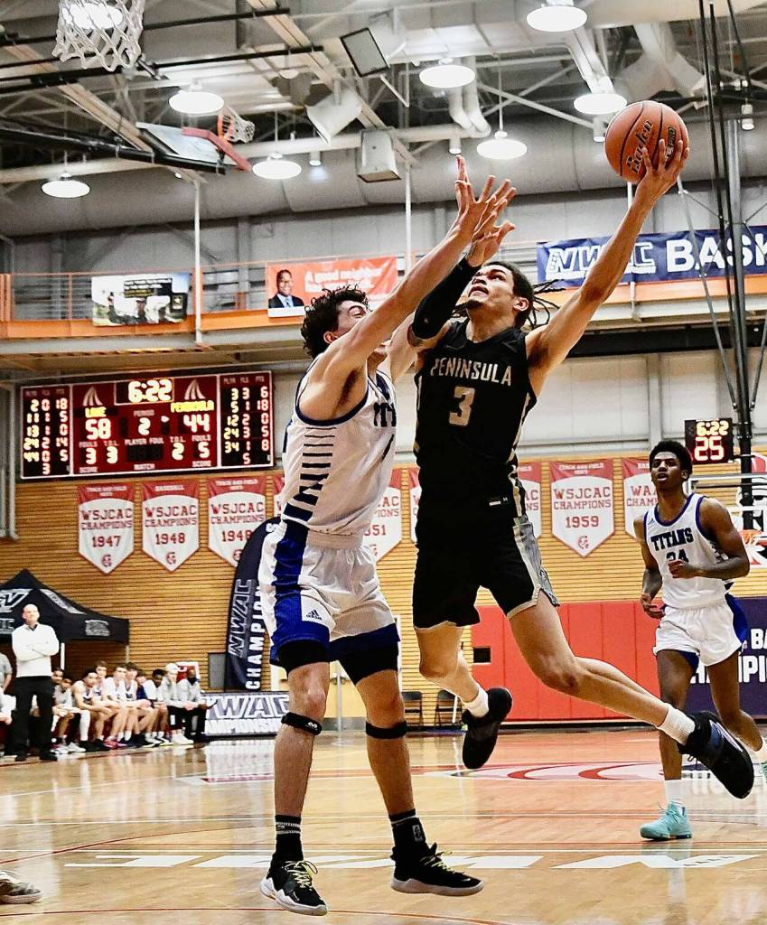 Peninsulas Jaylin Reed, right, looks to drive past Lanes Ethan Blythe to the basket in an NWAC tournament first round game in Everett in March 17. Reed had 20 points in Peninsulas 82-68 loss to the top-seeded Titans. Photo by Jay Cline/Peninsula College
