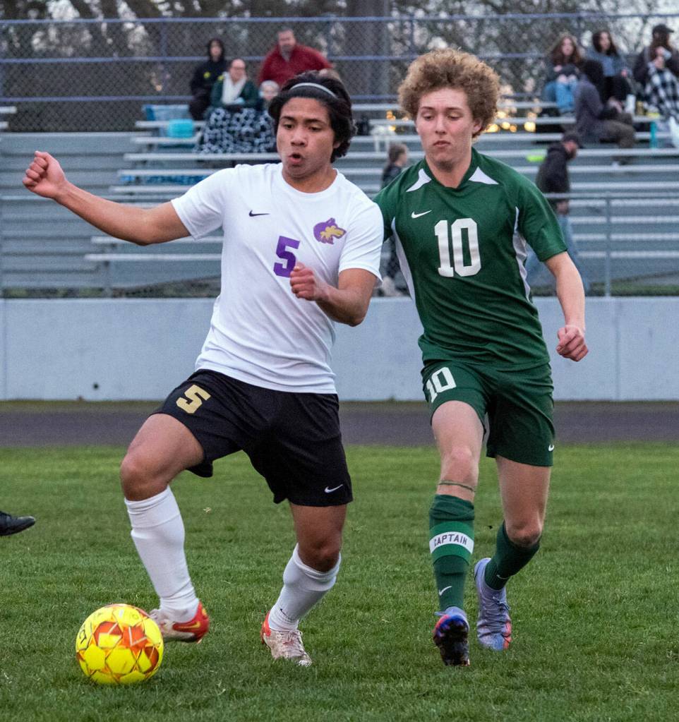 Sequims Cristian Gonzalez, left, keeps possession from Port Angeles Damon Gunderson as the Wolves blank the visiting Roughriders 5-0 in March 17. Sequim Gazette photo by Emily Matthiessen