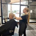 Nikhita Rogers, owner/operator of Fades and Shaves Barbering, gives a haircut to her grandfather Art Rodgers, former owner of Art’s Barbershop. Nikhita is the daughter of Lisalesa Rogers, former owner of A Classic Clip barbershop. Submitted photo