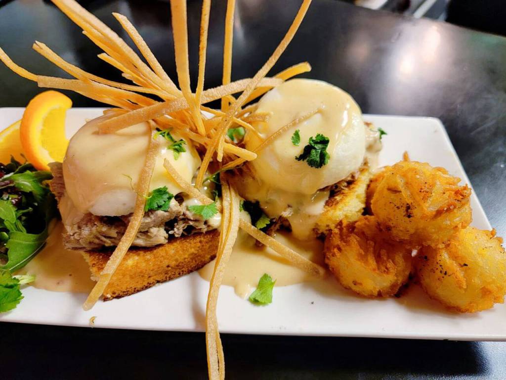 Try a Southern Joe  grill cakes (grilled, homemade cornbread) topped with verde pork, poached egg, Chipotle hollandaise and fried tortilla strips  at the newly-reopened Sunshine Café. Photo courtesy of Kyla Washburn/Sunshine Café