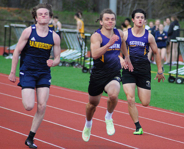 Sequims Tyler Mooney, center, and Henry Hughes, right, race for a top spot against Bainbridges Mathurin Le Dorze and others in the 100-meter race on April 14 in Kingston. Le Dorze placed first in 11.75 seconds, followed by Mooney (11.88), Bainbridges Micah Bryant (12.31) and Hughes (12.48). Photo taken by Joanne Carroll-Huemoeller
