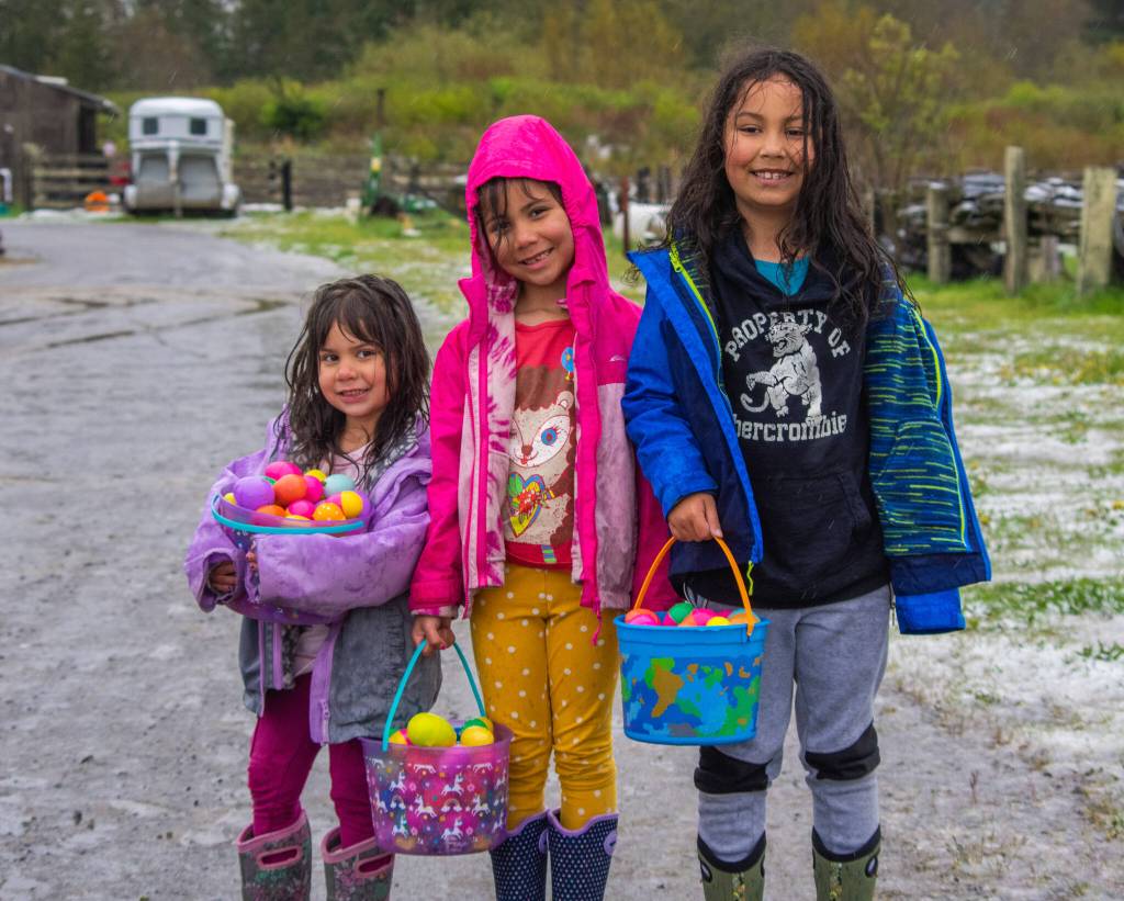 Sequim Gazette photo by Emily Matthiessen
From left, Camilla Peterson, 3, Delphina Peterson, 6, and Logan Peterson, 8, were enthusiastic participants at three egg hunts, finishing up in the snow and hail at KSQM 91.5 FM and the Pumpkin Patchs hunt off Highway 101. Drenched and happy, they pose for a picture before returning home.