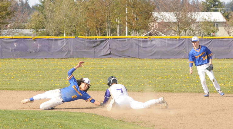 Sequims Connor Bear slides in just before the tag at second base as the Wolves take on Bremerton on April 19 at home. Trying to make the tag for the Knights is Brian Infante. Sequim Gazette photo by Michael Dashiell