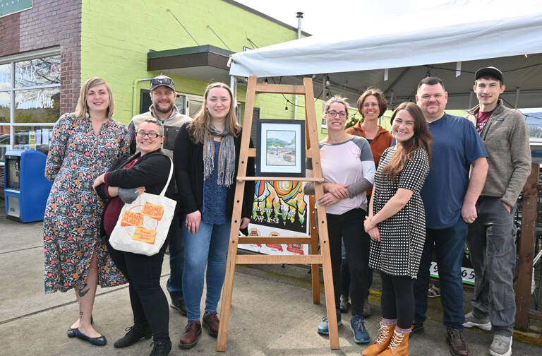 Sequim Gazette photo by Michael Dashiell
Celebrating the upcoming Sequim Farmers & Artisans market season  and the reveal of SFAM artwork by Sarah Necco  are, from left, SFAM board members Stephanie Parker, Rachel Anderson and Silas Crews, Necco, Rainshadow Café owner Dominique Hall, board members Elli Rose, Eric Pickens and Sam Konovalov, and Emma Jane Garcia, director for the Sequim Farmers & Artisans Market.