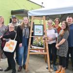 Sequim Gazette photo by Michael Dashiell
Celebrating the upcoming Sequim Farmers & Artisans market season  and the reveal of SFAM artwork by Sarah Necco  are, from left, SFAM board members Stephanie Parker, Rachel Anderson and Silas Crews, Necco, Rainshadow Café owner Dominique Hall, board members Elli Rose, Eric Pickens and Sam Konovalov, and Emma Jane Garcia, director for the Sequim Farmers & Artisans Market.