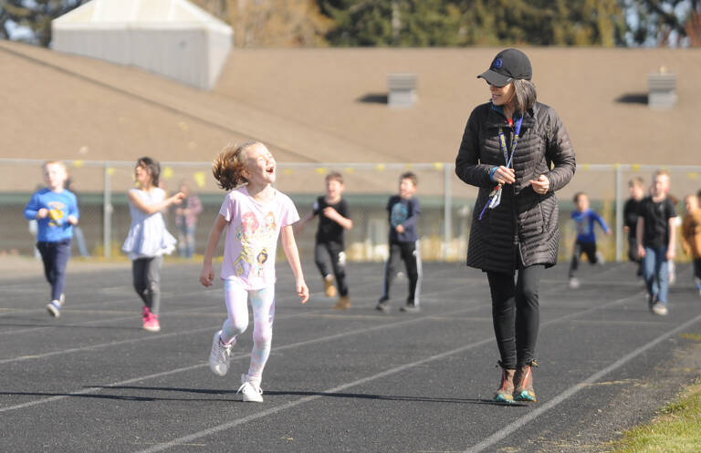 First-grader Olivia Wright and her teacher Ione Marcy share a moment at Helen Haller Elementary's School's annual Fun Run, held on Earth Day (April 22). Sequim Gazette photo by Michael Dashiell