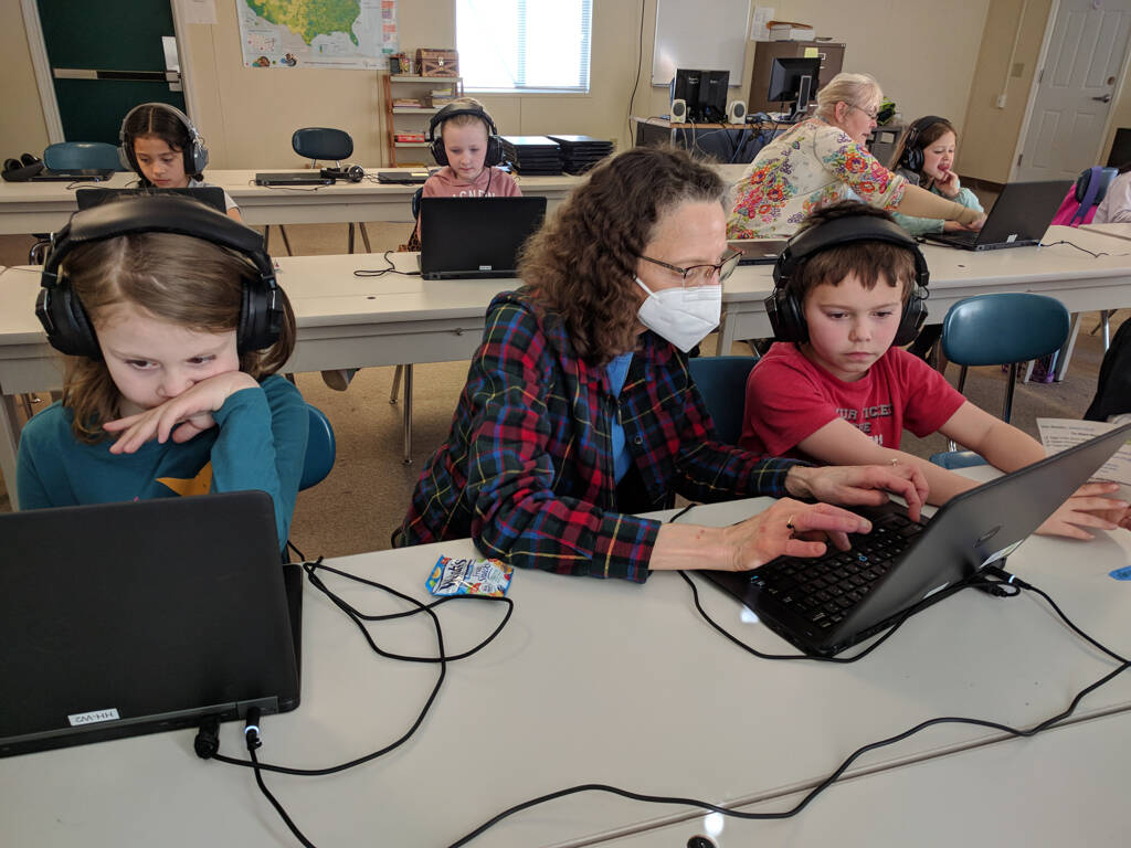 Photos by Henry N. Smith
Betsy Smith, reading specialist at Helen Haller Elementary School, helps students River Baker Hendrickson, left, and Jaxon Strait use the online Reading Success with Fluency program during after-school Star Reader Club time.