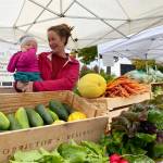Emma Jane Garcia/Sequim Farmers Artisans Market
Get veggies and more at Rhea Sunshine Farms booth at the Sequim Farmers & Artisans Market. Pictured is Lindsey Soha, holding Rhea.