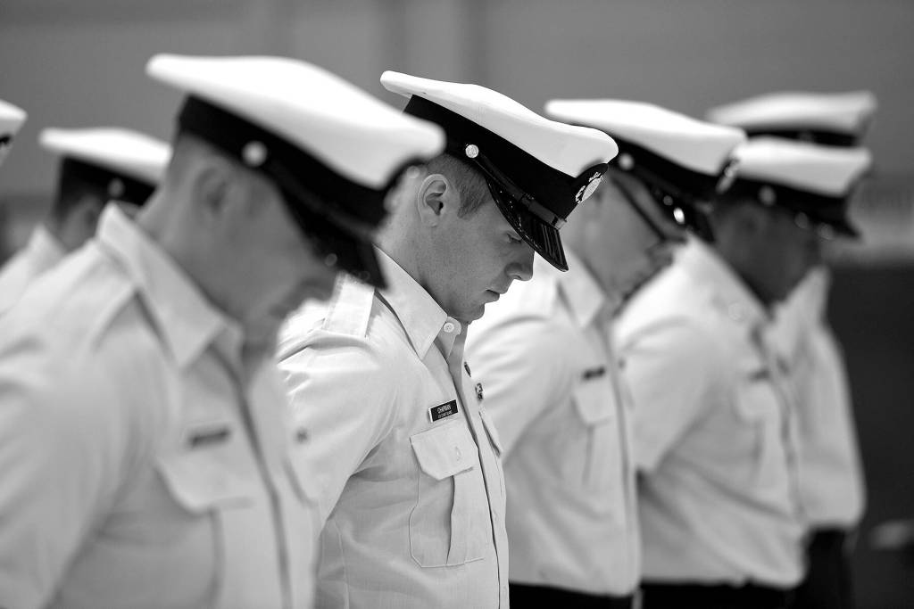 The crew of Coast Guard Cutter Cuttyhunk (WPB 1322) bow their heads during a benediction prayer starting the cutters decommissioning ceremony held Thursday, May 5, 2022, at Air Station Port Angeles. The crew would transition from the Cuttyhunk to the Anacapa, another 110-foot Island Class patrol boat which would in turn serve the Pacific Northwest. Photo by U.S. Coast Guard photo by Petty Officer 3rd Class Michael Clark