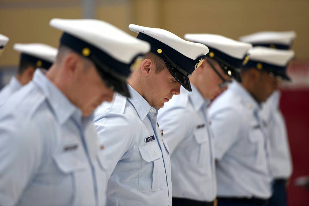 The crew of Coast Guard Cutter Cuttyhunk (WPB 1322) bow their heads during a benediction prayer starting the cutters decommissioning ceremony held Thursday, May 5, 2022, at Air Station Port Angeles. The crew would transition from the Cuttyhunk to the Anacapa, another 110-foot Island Class patrol boat which would in turn serve the Pacific Northwest. Photo by U.S. Coast Guard photo by Petty Officer 3rd Class Michael Clark