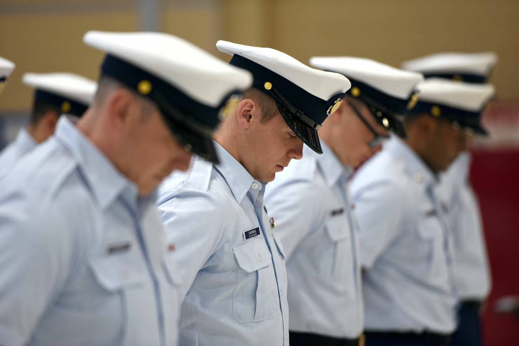 The crew of Coast Guard Cutter Cuttyhunk (WPB 1322) bow their heads during a benediction prayer starting the cutters decommissioning ceremony held Thursday, May 5, 2022, at Air Station Port Angeles. The crew would transition from the Cuttyhunk to the Anacapa, another 110-foot Island Class patrol boat which would in turn serve the Pacific Northwest. Photo by U.S. Coast Guard photo by Petty Officer 3rd Class Michael Clark