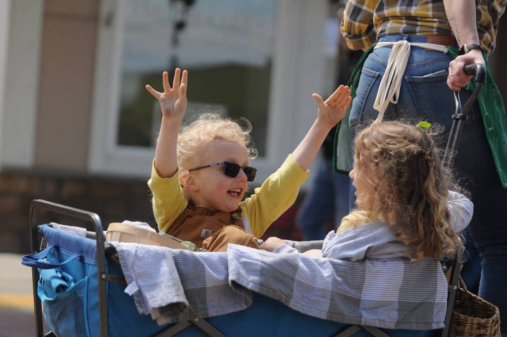The Thompson twins  Hazel and Jude  enjoy Saturdays Grand Parade in style as part of the Sequim Farmers & Artisans Market entry. Sequim Gazette photo by Michael Dashiell