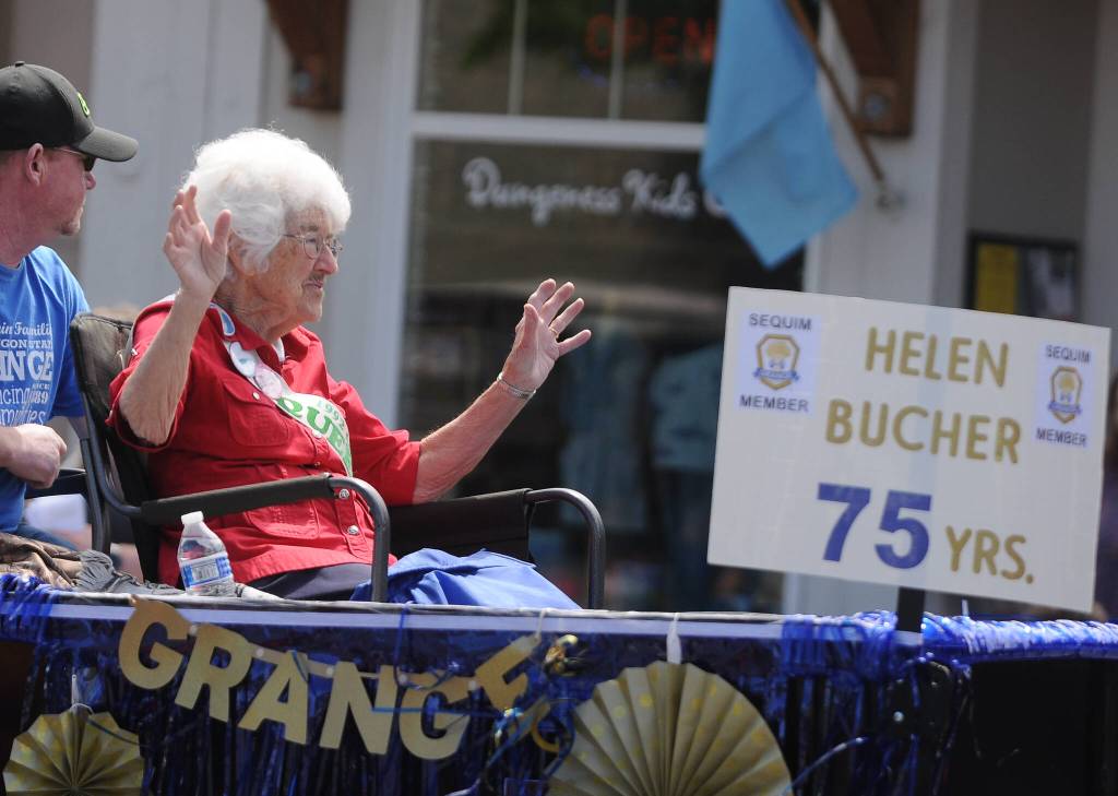 Helen Bucher, a member of the Sequim Prairie Grange for 75 years, waves to the crown at Saturdays Sequim Irrigation Festival Grand Parade. Sequim Gazette photo by Michael Dashiell