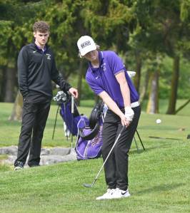 As teammate Dominic Riccobene looks on, Sequim's Ben Sweet hits a chip shot on the 11th hole in an April 28 Olympic League match against North Kitsap. Riccobene, Sweet and teammate Cole Smithson were slated to compete in the 2A state tournament this week in Olympia. Sequim Gazette file photo by Michael Dashiell