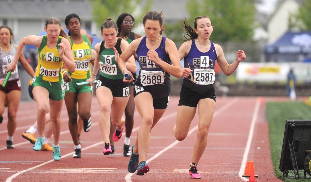 Sequim Gazette photos by Michael Dashiell 
Sequims Eve Mavy (2589) takes a handoff from teammate Kaitlyn Bloomenrader in the third leg of the Wolves state 2A title-winning 4x400 relay on May 28. Sequim edged Lynden by 0.09 of a second.