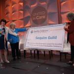Submitted photo
Ann Shanahan, a trustee with the Seattle Childrens Guild Association, presents a banner displaying the Chairmans Award to Sequim Guild president Kathy Bare and secretary Lydia Stanhope at the Seattle Childrens Guild Association 2022 Annual Meeting & Luncheon on May 13.
