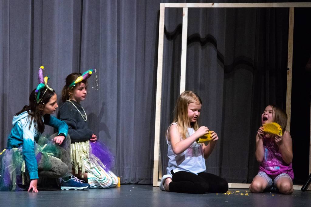 Tricksters played by Mia Buhrer and Matilda Woodbury watch the dragons played by Emma Abken and Bekah Abken eat specially prepared tacos. Sequim Gazette photo by Emily Matthiessen