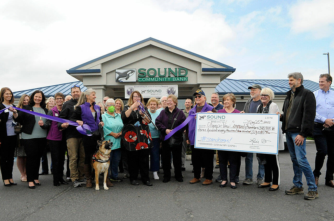 Sequim Gazette photo by Matthew Nash
Shelli Robb-Kahler, vice-president/ relationship manager with Sound Community Bank, cuts a ribbon on May 25 to celebrate the banks 25 years in Sequim and $390,358 in giving back to the community through its Community Card in partnership with the Olympic View Community Foundation.